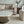 Modern living room with a gray sofa, marble coffee table, and decorative vase.