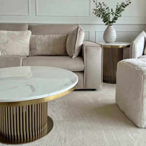 Modern living room with a gray sofa, marble coffee table, and decorative vase.