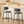 Two modern bar stools with textured gray fabric seats and backs on black metal frames, positioned in front of a white kitchen island with a sink and countertop.