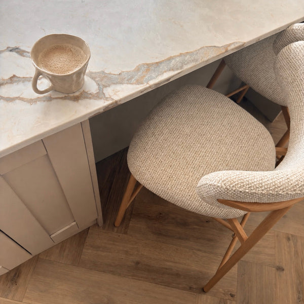 Dining area with marble countertop, chairs, and a cup.