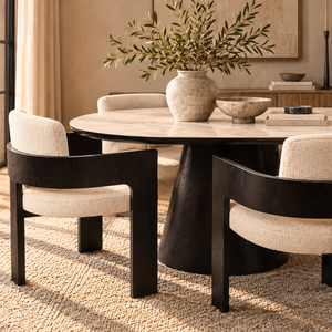 Black ceramic dining table with four beige upholstered chairs, rounded tabletops
