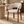 Upholstered dining chair with rounded beige armrests, curved back, walnut legs