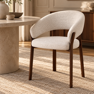 Upholstered dining chair with rounded beige armrests, curved back, walnut legs