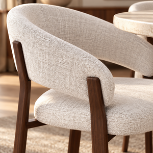 Upholstered dining chair with beige textured fabric seat and curved back, walnut arms