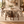 Walnut dining table set with round marble-look top and six beige upholstered chairs
