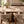 Walnut round dining table with marble-look surface and four beige upholstered chairs