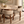 Walnut dining table with curved marble-look top and beige upholstered dining chairs