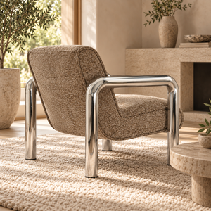 Brown upholstered armchair with a rounded back and polished metal frame, shown from the side