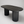 A modern oval dining table with a dark wood-grain top and two fluted cylindrical pedestal legs, shown on a neutral light gray background.