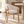 Light beige upholstered dining chair with curved wooden arms and straight legs