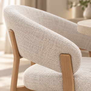 Beige upholstered dining chair close-up of rounded backrest and wooden arm