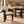 Pair of cream dining chairs with dark wood frames and armrests