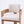 A modern wooden armchair with a light beige textured fabric seat and backrest, shown against a plain white studio background.