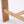 Close-up of a light natural wood furniture leg and crossbar joint on a white studio background.