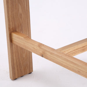 Close-up of a light natural wood furniture leg and crossbar joint on a white studio background.