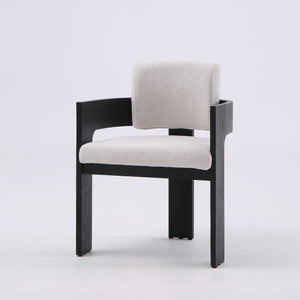 A modern accent chair featuring a black wooden frame and light beige textured fabric upholstery on the seat and backrest, set against a plain light gray studio background.