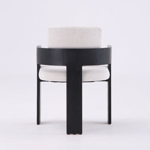 A modern accent chair featuring a black curved wooden frame and light beige textured fabric upholstery on the seat and backrest, set against a plain white studio background.