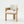 A modern accent chair featuring a light natural wood frame and textured off-white fabric upholstery on the seat and backrest, set against a seamless white studio background.