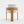 A modern wooden dining chair with a curved light oak frame and light beige textured bouclé upholstery on the seat and back cushion, shown against a plain white studio background.