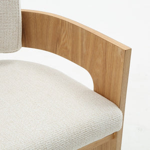 Close-up of a modern wooden chair with a curved light oak frame and textured off-white woven upholstery on the seat and backrest, set against a plain white background.