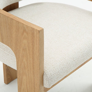 Close-up of a modern wooden dining chair with a light beige textured woven fabric seat cushion and natural oak wood frame.
