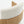Close-up of a curved wooden chair with a thick, textured cream fabric backrest and seat cushion on a white background.