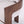 Close-up of a modern upholstered chair with a curved dark walnut wood frame and textured off-white fabric seat and back.