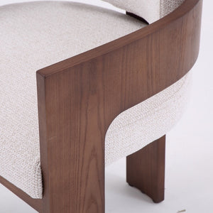 Close-up of a modern upholstered chair with a curved dark walnut wood frame and textured off-white fabric seat and back.