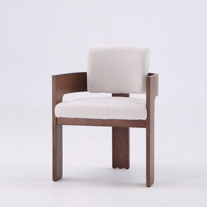 A modern wooden armchair with a light beige textured fabric seat and backrest, set against a plain white studio background.