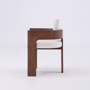 A modern wooden dining chair with a curved armrest, upholstered in a textured off-white fabric, shown from the side against a plain white background.
