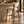 Walnut barstool with light beige upholstered seat and curved backrest, footrest brace