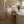 Modern kitchen with light wood cabinets, marble countertops, and pendant lights.