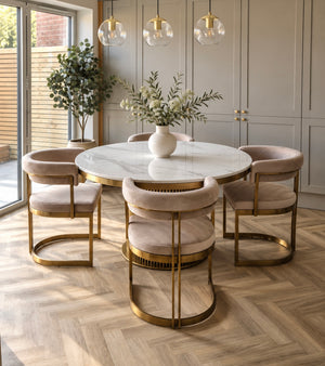 Round white marble dining table with gold base and veined stone tabletop