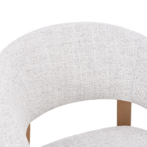 Close-up of light gray upholstered dining chair backrest with curved top
