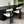 A modern dining table set in a contemporary dining room. The set features a dark oval-shaped table with a fluted base and four matching chairs upholstered in a textured cream bouclé fabric.