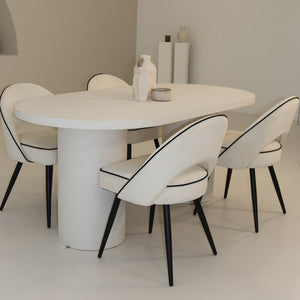 Modern dining room with a white round table and chairs.