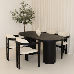 Black micro cement dining table with four white bouclé chairs
