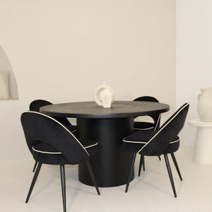Dining table with black chairs in a minimalistic room