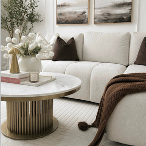Modern living room with white sofa, marble coffee table, and abstract art on the wall.