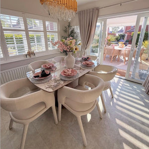 Dining room with a table set for four, chairs, and a chandelier.