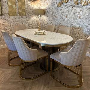 Dining room with marble table and chairs against a decorative wall.