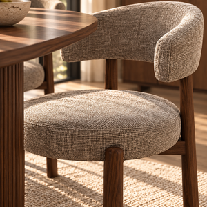 Light gray upholstered dining chair with rounded arm and walnut legs