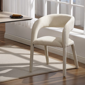 White chair in a room with large windows and a table.