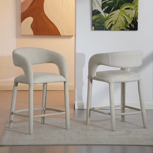 Two stools in a room with abstract art on the walls.