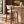 Walnut barstool with light beige upholstered seat, curved backrest, slim walnut legs