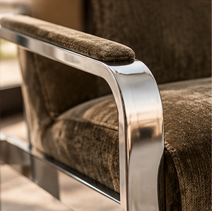 Corra khaki armchair detail with textured upholstery and polished metal armrest