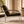 Corra khaki armchair in side view, with padded arms and a polished metal frame