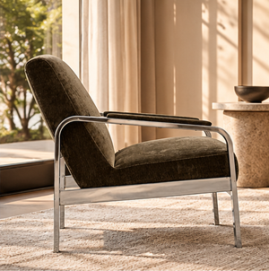 Corra khaki armchair in side view, with padded arms and a polished metal frame