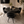 Dining room with a round black table and four matching chairs on a wooden floor.