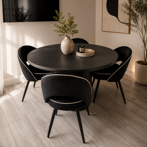 Dining room with a round black table and four matching chairs on a wooden floor.